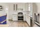 Updated kitchen featuring white cabinets, stainless steel appliances, modern countertops, and center island at 3610 Olive St, Denver, CO 80207
