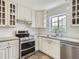 Updated kitchen featuring white cabinets, stainless steel appliances, and modern countertops at 3610 Olive St, Denver, CO 80207
