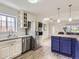 Bright kitchen featuring stainless steel appliances, white cabinets, and an adjacent island with bar seating at 3610 Olive St, Denver, CO 80207