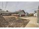 Backyard featuring a grey house, brick foundation, and a concrete patio area at 828 S Osceola St, Denver, CO 80219
