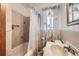 Bathroom showcasing a vanity, bathtub with shower, decorative tile, and natural lighting at 828 S Osceola St, Denver, CO 80219