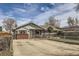 A charming one-story home with a fenced yard, inviting curb appeal, and driveway at 828 S Osceola St, Denver, CO 80219