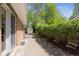 Landscaped backyard with a brick home exterior, tall hedges, and a storage shed at 1522 Utah St, Golden, CO 80401