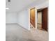 Spacious basement featuring gray carpet, neutral walls, and a wooden door leading to a lower-level stairway at 1522 Utah St, Golden, CO 80401