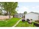 Beautiful backyard boasts lush lawn, mature trees, and an inviting fire pit area at 4406 S Delaware St, Englewood, CO 80110