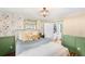 Bright bedroom with floral wallpaper, a built-in closet, and green trim at 4406 S Delaware St, Englewood, CO 80110