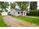 Charming home with gray siding, a red front door, and a detached garage at 4406 S Delaware St, Englewood, CO 80110