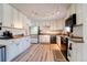 Bright kitchen with white cabinets, modern appliances, and beautiful flooring at 701 Tucson, Aurora, CO 80011