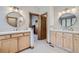 Bathroom featuring dual sinks, wood cabinetry, and well-lit mirrors, creating a functional space at 31058 Big Bear Dr, Evergreen, CO 80439