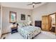 Cozy bedroom featuring a ceiling fan, floral bedding, and natural light from two well-placed windows at 31058 Big Bear Dr, Evergreen, CO 80439