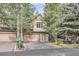 Two-story home featuring a two-car garage, a private porch, and mature trees at 31058 Big Bear Dr, Evergreen, CO 80439
