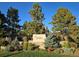 Community sign featuring the Lodges at Eagles Nest surrounded by trees, landscaping, and stacked stone base at 31058 Big Bear Dr, Evergreen, CO 80439