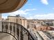 An ornate balcony offers a breathtaking view of the city skyline and street, showcasing blue sky and neighborhood charm at 925 N Lincoln St # 12G, Denver, CO 80203
