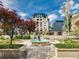 Well-manicured courtyard featuring a fountain surrounded by lush trees and greenery, set against a building backdrop at 925 N Lincoln St # 12G, Denver, CO 80203