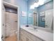 Serene bathroom featuring blue walls, a white vanity with a large mirror, and a shower with decorative curtain at 5404 W 95Th Pl, Westminster, CO 80020
