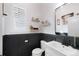 Stylish powder room with black wainscoting, modern fixtures, and elegant decor at 5404 W 95Th Pl, Westminster, CO 80020