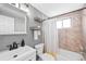 Cozy bathroom featuring a modern vanity, floating shelves, and tiled shower-tub combo at 148 S Emerson St # 206, Denver, CO 80209
