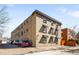 Exterior view of a three-story brick apartment building with shaded windows at 148 S Emerson St # 206, Denver, CO 80209