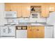 Efficient kitchen with light wood cabinets, white appliances, and open shelving above the countertop at 148 S Emerson St # 206, Denver, CO 80209