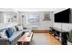 Comfortable living room featuring a modern couch, wood floors, and a large TV at 148 S Emerson St # 206, Denver, CO 80209