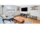 Comfortable living room featuring a modern couch, wood floors, and a large TV at 148 S Emerson St # 206, Denver, CO 80209