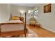 Bedroom with wood floors, cozy chair and ottoman, and a bright window with valance at 435 Cody Dr, Lakewood, CO 80226
