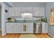 Bright kitchen featuring white cabinets, stainless steel dishwasher, and blue countertops at 435 Cody Dr, Lakewood, CO 80226