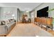 Open concept living area with hardwood flooring, a gray sofa, a dining table, and a large television at 435 Cody Dr, Lakewood, CO 80226