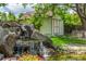 Backyard with rocks, greenery, waterfall feature, and a bench for relaxing at 3525 S Brentwood St, Lakewood, CO 80235
