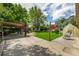 Relaxing backyard with covered patio, green lawn, and lush landscaping at 3525 S Brentwood St, Lakewood, CO 80235