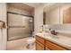 Cozy bathroom features a shower and tub combo and a oak wood vanity at 3525 S Brentwood St, Lakewood, CO 80235