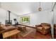 Bright living room with wood floors, a wood-burning stove, and a large window at 3525 S Brentwood St, Lakewood, CO 80235