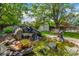 Landscaped backyard with stone waterfall, pond, and wooden shed at 3525 S Brentwood St, Lakewood, CO 80235