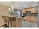 Kitchen with wooden cabinets, stainless steel appliances and bar seating at 7266 S Birch St, Centennial, CO 80122