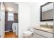Bathroom and laundry area with a granite countertop vanity, wood floors, and washer and dryer hookups at 13812 W 64Th Pl, Arvada, CO 80004
