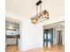 Open-concept area with hardwood floors, designer lighting, flowing into the kitchen and living spaces at 13812 W 64Th Pl, Arvada, CO 80004