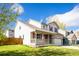 Attractive two-story home with covered porch and manicured lawn on a sunny day at 13812 W 64Th Pl, Arvada, CO 80004