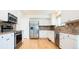 Modern kitchen featuring stainless steel appliances, granite countertops, and ample cabinet space at 13812 W 64Th Pl, Arvada, CO 80004