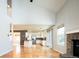 Open-concept living space with vaulted ceilings, fireplace, and access to the kitchen and dining area at 13812 W 64Th Pl, Arvada, CO 80004