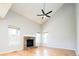 Living room with brick fireplace, ceiling fan, vaulted ceiling, and multiple windows at 13812 W 64Th Pl, Arvada, CO 80004