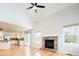 Living room with vaulted ceiling, brick fireplace, and an open layout to the kitchen at 13812 W 64Th Pl, Arvada, CO 80004