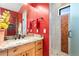 Bathroom with red wall, wooden cabinets, granite countertop, and walk-in shower at 8456 N Sundown Trl, Parker, CO 80134