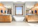 Modern bathroom featuring double sink vanity, soaking tub with view, and stylish lighting fixtures at 8456 N Sundown Trl, Parker, CO 80134
