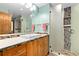 Bathroom featuring a tile shower, tile accents, and wood vanity with double mirror at 8456 N Sundown Trl, Parker, CO 80134