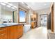 Bright bathroom with double sinks, soaking tub under large window, and door leading to bedroom at 8456 N Sundown Trl, Parker, CO 80134