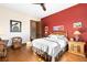 Cozy bedroom with hardwood floors, red accent wall, and a ceiling fan at 8456 N Sundown Trl, Parker, CO 80134