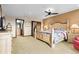 Spacious bedroom featuring a ceiling fan, warm carpet and paint, and connecting bathroom and closet at 8456 N Sundown Trl, Parker, CO 80134