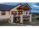 Stone home with covered patio featuring a hot tub and outdoor living space, complete with an American flag at 8456 N Sundown Trl, Parker, CO 80134