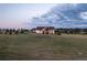 Wide view showcases this magnificent stone home with a sprawling lawn and mature trees at 8456 N Sundown Trl, Parker, CO 80134