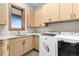 Well-lit laundry room with washer, dryer, sink, and ample cabinet space at 8456 N Sundown Trl, Parker, CO 80134